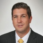 man wearing suit and tie, smiling. 