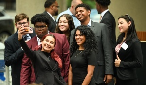 a group of young adults gathered to take a photo. 