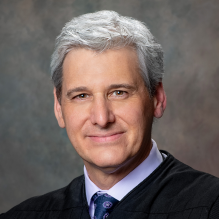 a portrait photo of a man in judge's robe,.