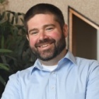 man smiling, arms crossed.