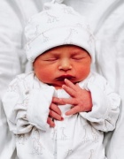 baby wrapped in white swaddling.