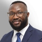 man wearing business suit and glasses, smiling.