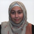 young woman smiling, wearing a hijab. 