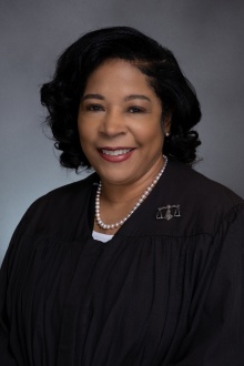 Woman wearing judges robe, smiling.