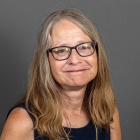 woman wearning glasses, smiling. 