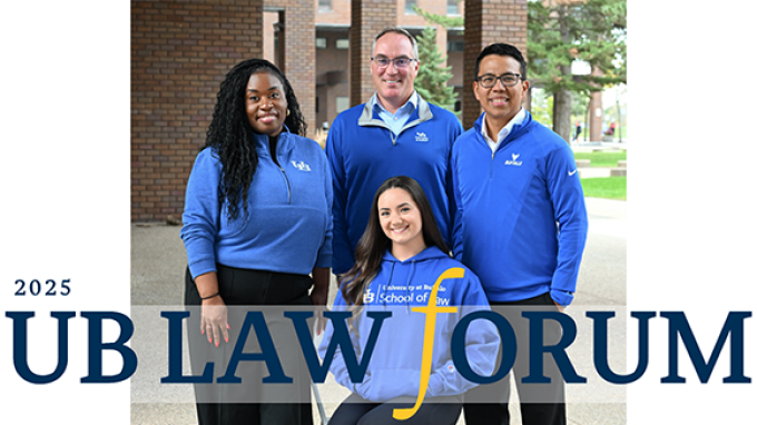 Four adults wearing blue UB Law apparel pose together outdoors on campus, with brick buildings and greenery in the background, alongside text reading “2025 UB Law Forum.”.