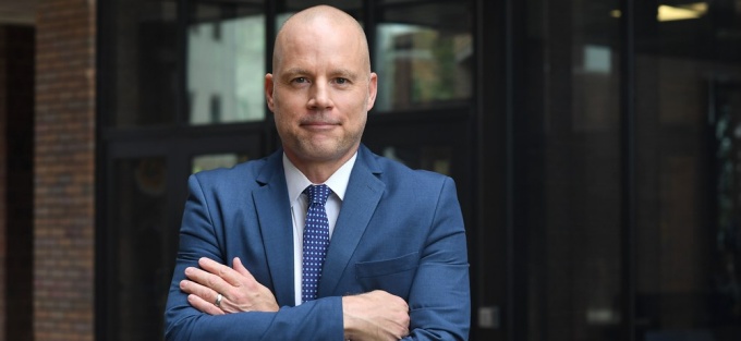 man standing outside with arms crossed.