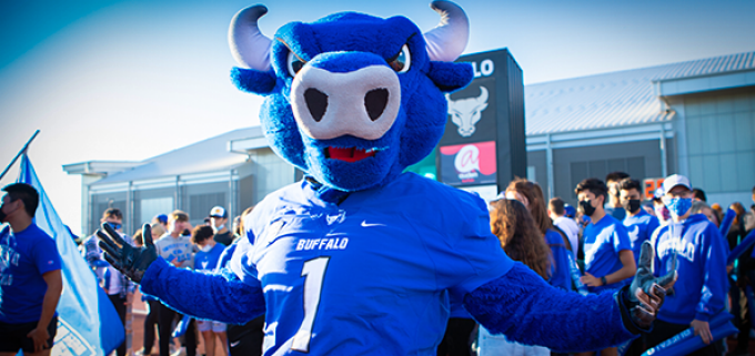 photo of UB Bulls mascot in a crowd of people cheering for the team. 