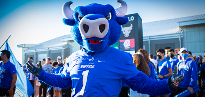 photo of UB Bulls mascot in a crowd of people cheering for the team.