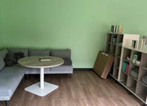 Zoom image: room with l-shaped sofa, wooden floorsn, coffee table and bookshelves