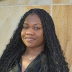 Khalia Muir standing in front of a marble wall.