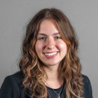 Rachel Doane wearing black jacket, top and gold necklace.