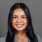 Maria Sansone wearing grey jacket and gold necklace.