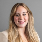 Caleigh Castlevetere wearing cream-colored jacket, smiling.