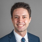 Max Battaglia wearing blue suit and tie.