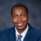 Andre Lloyd Jr. wearing blue jacket, tie, smiling.