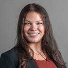 Taylor Wild wearing black jacket, brown top.