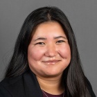 Julia Livingston wearing black jacket, gold necklace, smiling.
